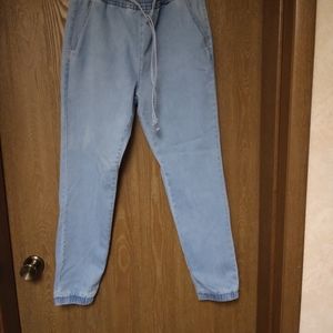 Light colored blue jeans with elastic in the waist and around the ankles.